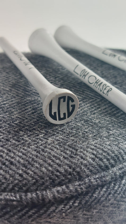 Low Chaser Golf white tees, on a charcoal headcover.