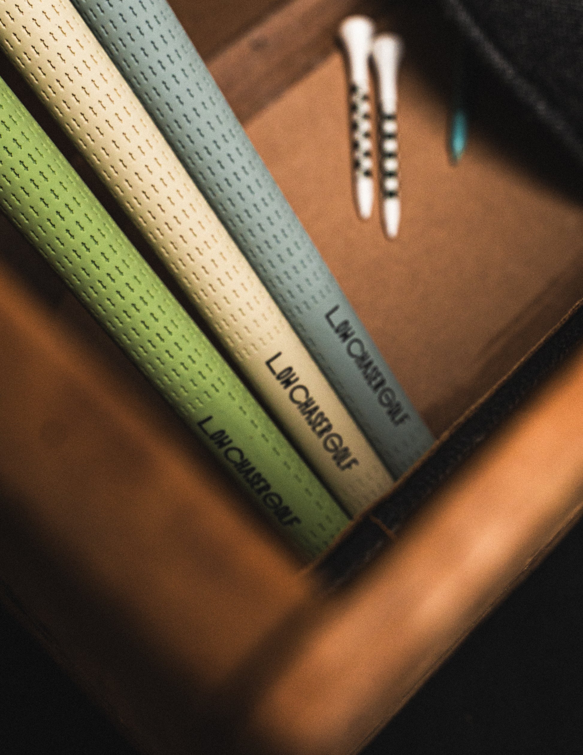 Baby Blue, cream and pastel green Golf Grips by Low Chaser Golf, set in a dark suitcase