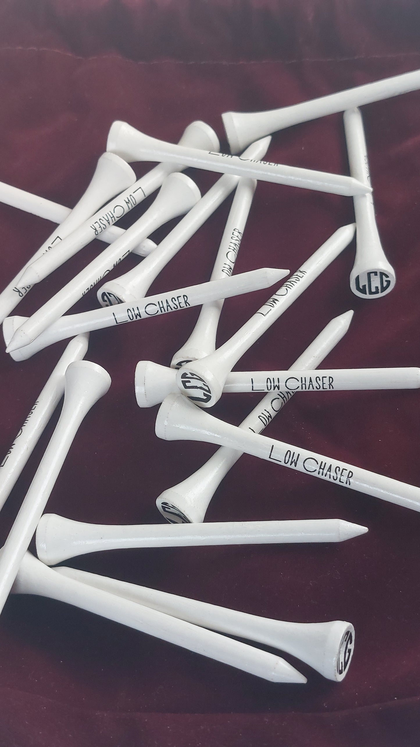 White Low Chaser Golf Tees on a burgundy cloth